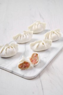 Frozen dumplings stuffed with liver and provencal herbs on marble serving plate
