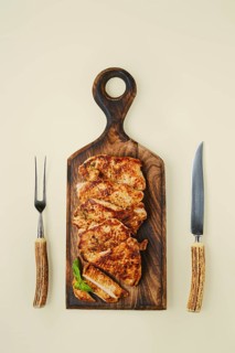 Overhead view of fried chopped pork tenderloin on wooden cutting board