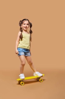 Young happy girl learning to ride on skateboard