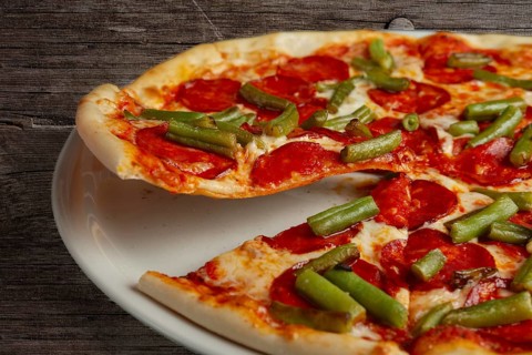 Slice of pizza pepperoni on scapula. Levitatating piece of pizza