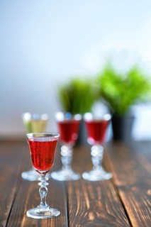 Vodka infused with berries on wooden background