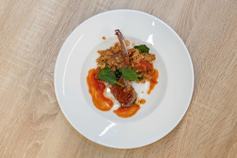 Top view of fried lamb rib with quinoa porridge on wooden table