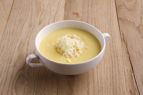 Soup puree with cheese and mushrooms on wooden table