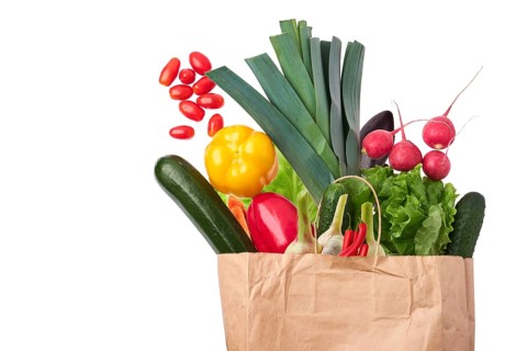 Paper bag with fresh vegetables isolated on white background