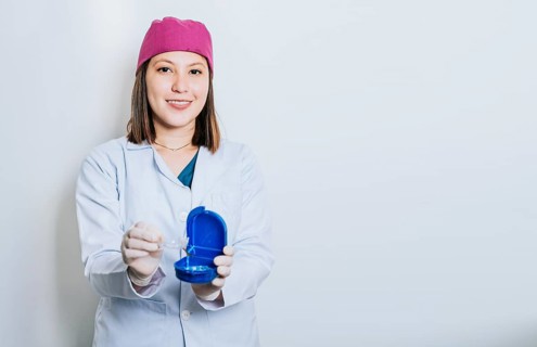A dentist with retainers on isolated background