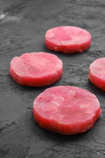 Fresh raw round tuna cutlet on wooden background