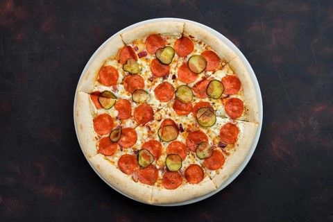 Top view of pizza with pickled cucumber and pepperoni sausage