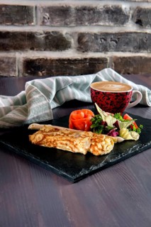 Omelette with salmon on slate plate and cup of latte