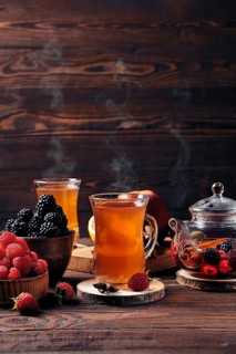 Freshly brewed fruit and herbal tea in kettle and two cups