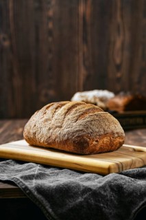 Loaf of artisan sourdough bread with porous texture on wooden table