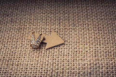 Mini crown and a paper arrow on canvas