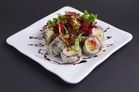 Spring rolls in omelet with fresh salad and spicy caramel sauce