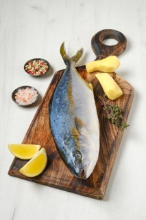 Whole fresh chinook on wooden cutting board with spice