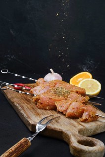 Pouring with sweet and spicy rub raw turkey meat on dark background