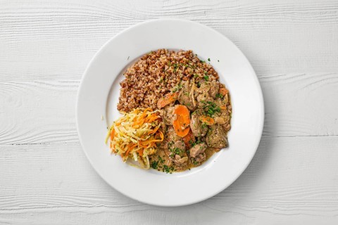 Top view of plate with chicken liver with buckwheat and pickled cabbage salad