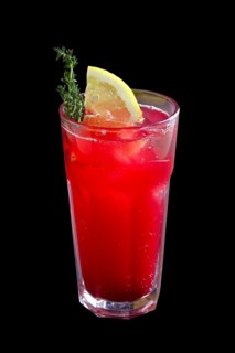 Glass of cranberry and lemon lemonade isolated on black