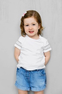 Two years old girl in white t-short and jeans shorts posing in studio