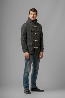 Full length portrait of handsome man in warm woolen coat posing in studio