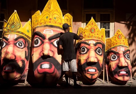 Artisan painting on a face of Ravana idol ahead of Dussehra Festival