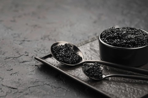 Black caviar bowl with spoons ladle