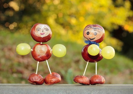 Two chestnut figures with grapes in the evening light