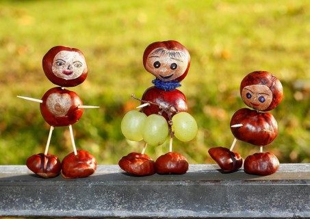Three chestnut figures with grapes in the evening light