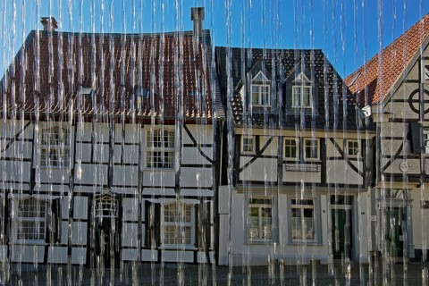 Half-timbered houses behind water from the weavers' well at Tuchmacherplatz