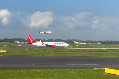 Two aircraft passenger jets jets jets jets in front Corendon Airlines in the back Condor on parallel runway runway during simultaneous takeoff takeoff and landing touchdown at Duesseldorf Internationa...