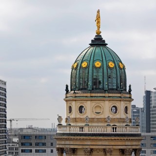 The domed tower of the German Cathedral at Gendarmenmarkt in front of newly built skyscrapers