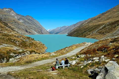 Three hikers resting at the Mattmark reservoir