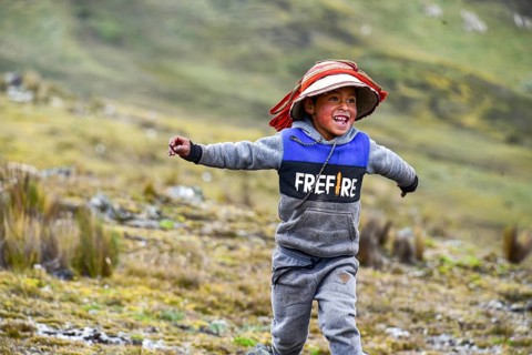 Running boy with traditional hat in the Andes