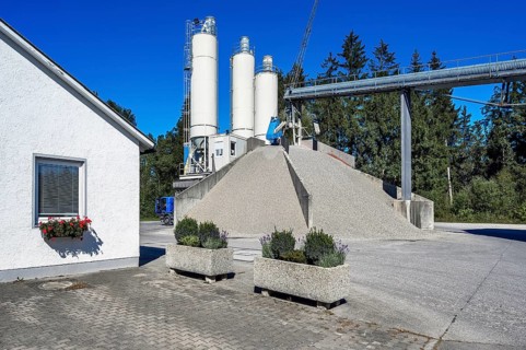 Steel silos and shovel crane with gravel piles and conveyor belt