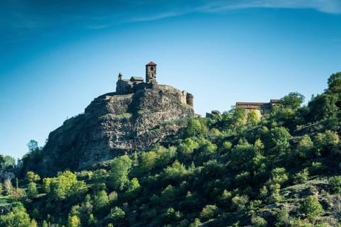 Saint-Ilpize castle perched on a volcanic peak above river Allier. Haute-Loire department. Auvergne-Rhone-Alpes. France