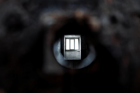 View through peephole into dark prison cell