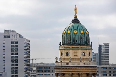 The domed tower of the German Cathedral at Gendarmenmarkt in front of newly built skyscrapers