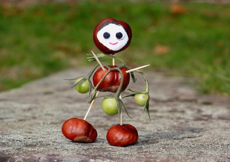 Cute chestnut figure with small tomatoes on wall
