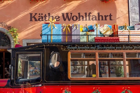 Decorated vintage bus with gift packages on the roof in front of the house of Kaethe Wohlfahrt Weihnachtsdorf