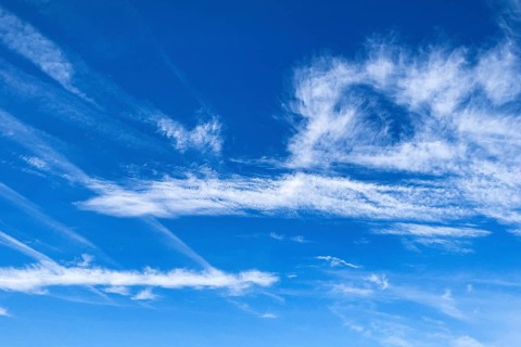 Blue sky with Cirrus feather clouds on the left Cirrocumulus cluster clouds on the right