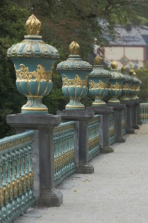 A row of golden lidded vases on a balustrade in the castle garden