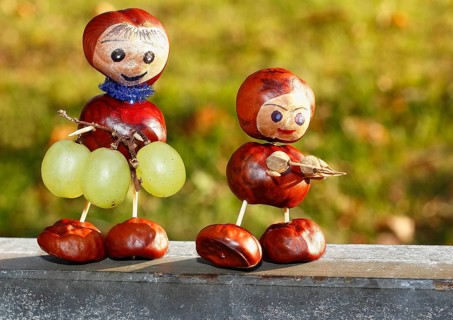 Two chestnut figures with grapes in the evening light