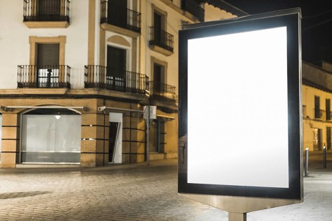 Illuminated lightbox billboard near apartment building