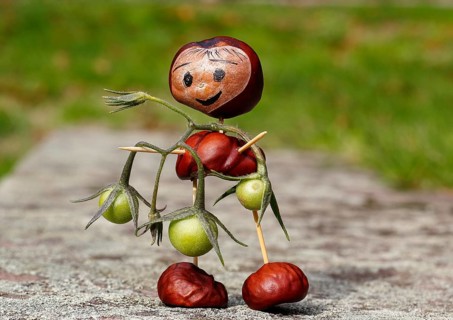 Cute chestnut figure with small tomatoes on wall