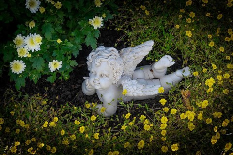 Grave with stone putto between flowers
