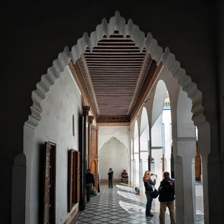 View through arched door to arcade with ornate wooden ceiling