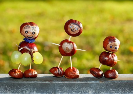 Three chestnut figures with grapes in the evening light