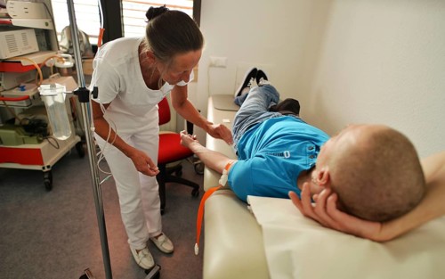 This internist in the centre of a larger city works mainly as a family doctor. The photo shows: A doctor's assistant putting in an infusion