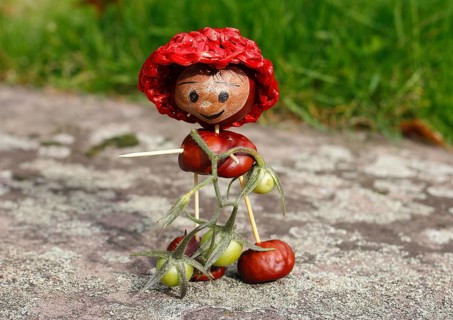 Cute chestnut figure with small tomatoes on wall