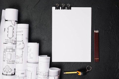 Blank paper with blueprints on table