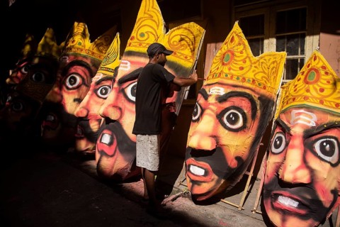 Artisan painting on a face of Ravana idol ahead of Dussehra Festival