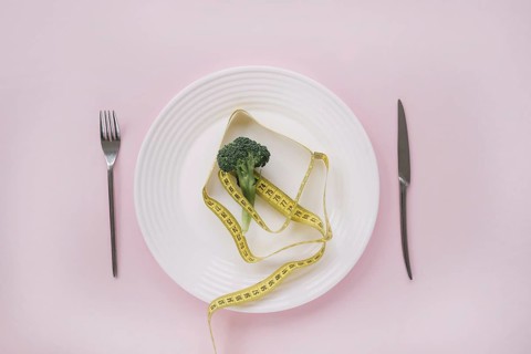 Broccoli and measurement tape on a dish